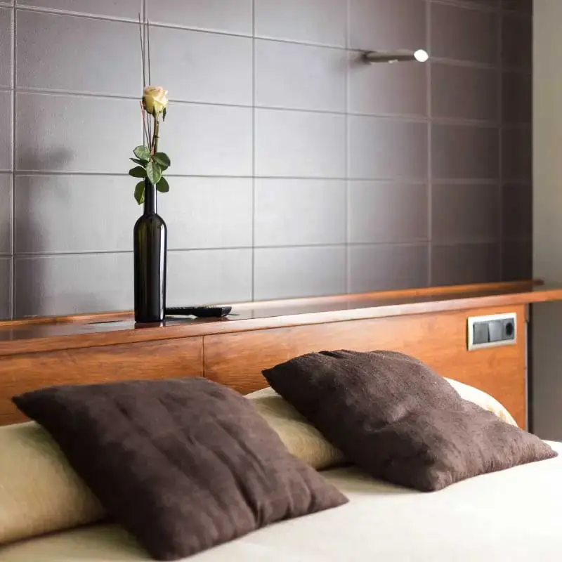 Cama doble con cojines y cabecero de madera