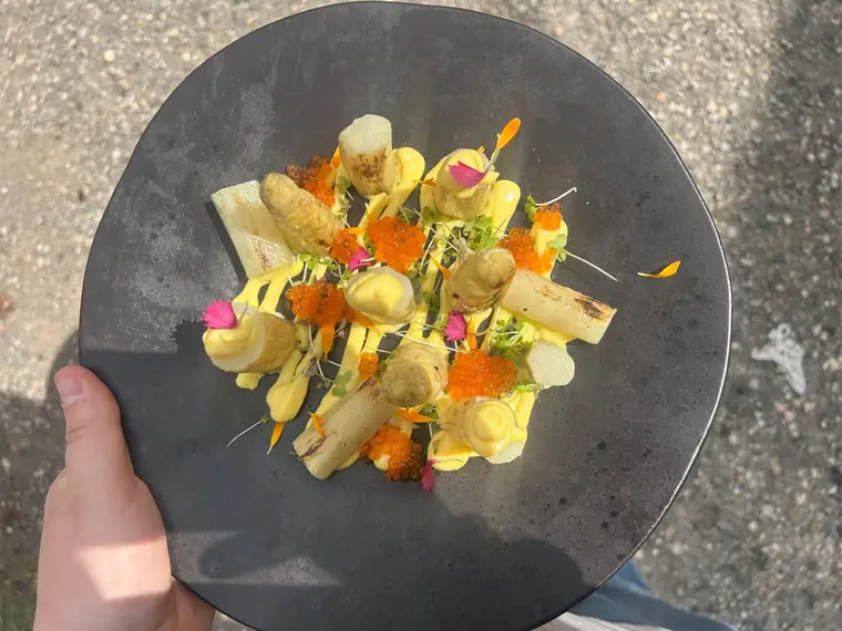 Espàrrecs amb salsa i flors sobre pissarra